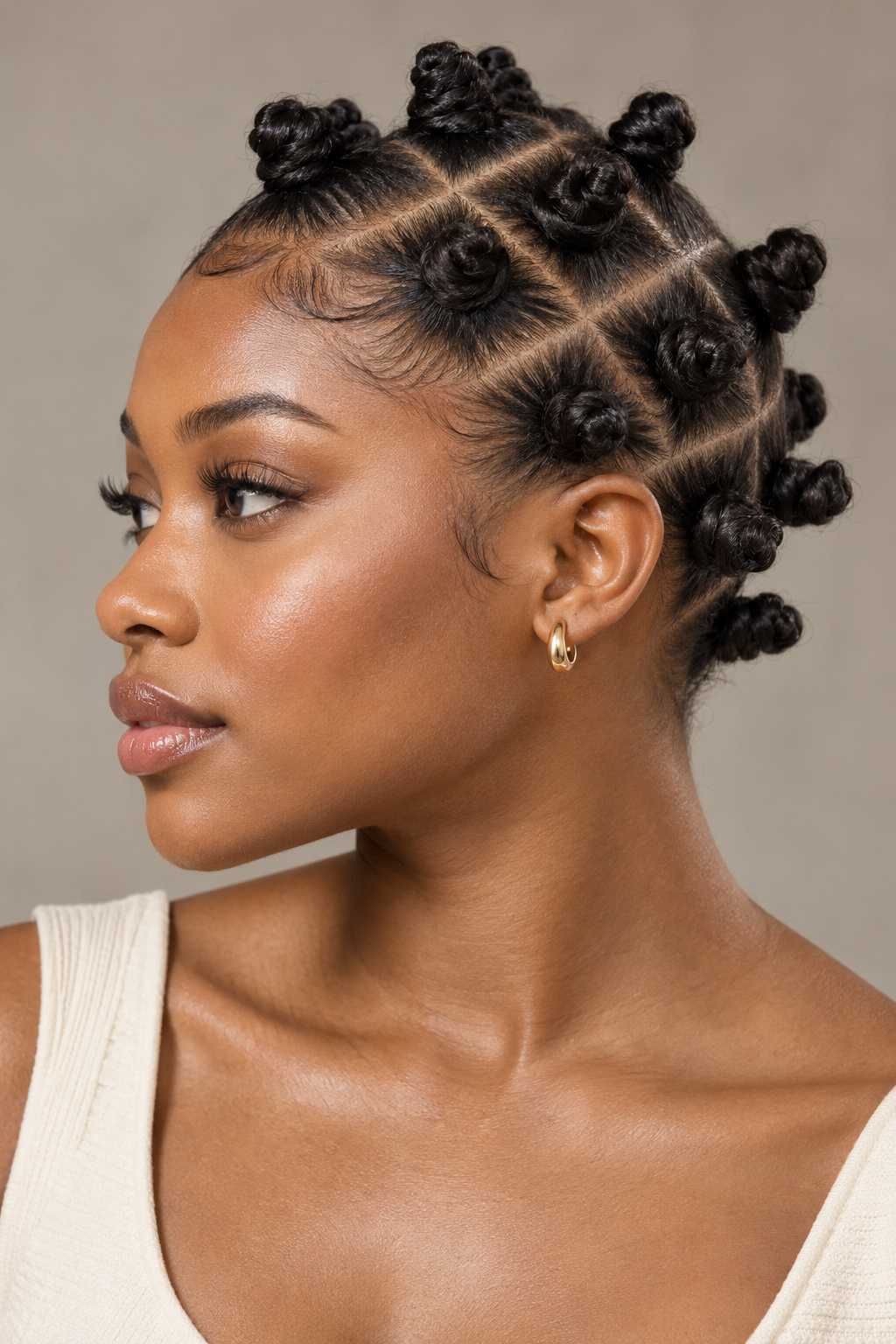 Side-view portrait showing small Bantu knots arranged along sharply angled scalp partings.