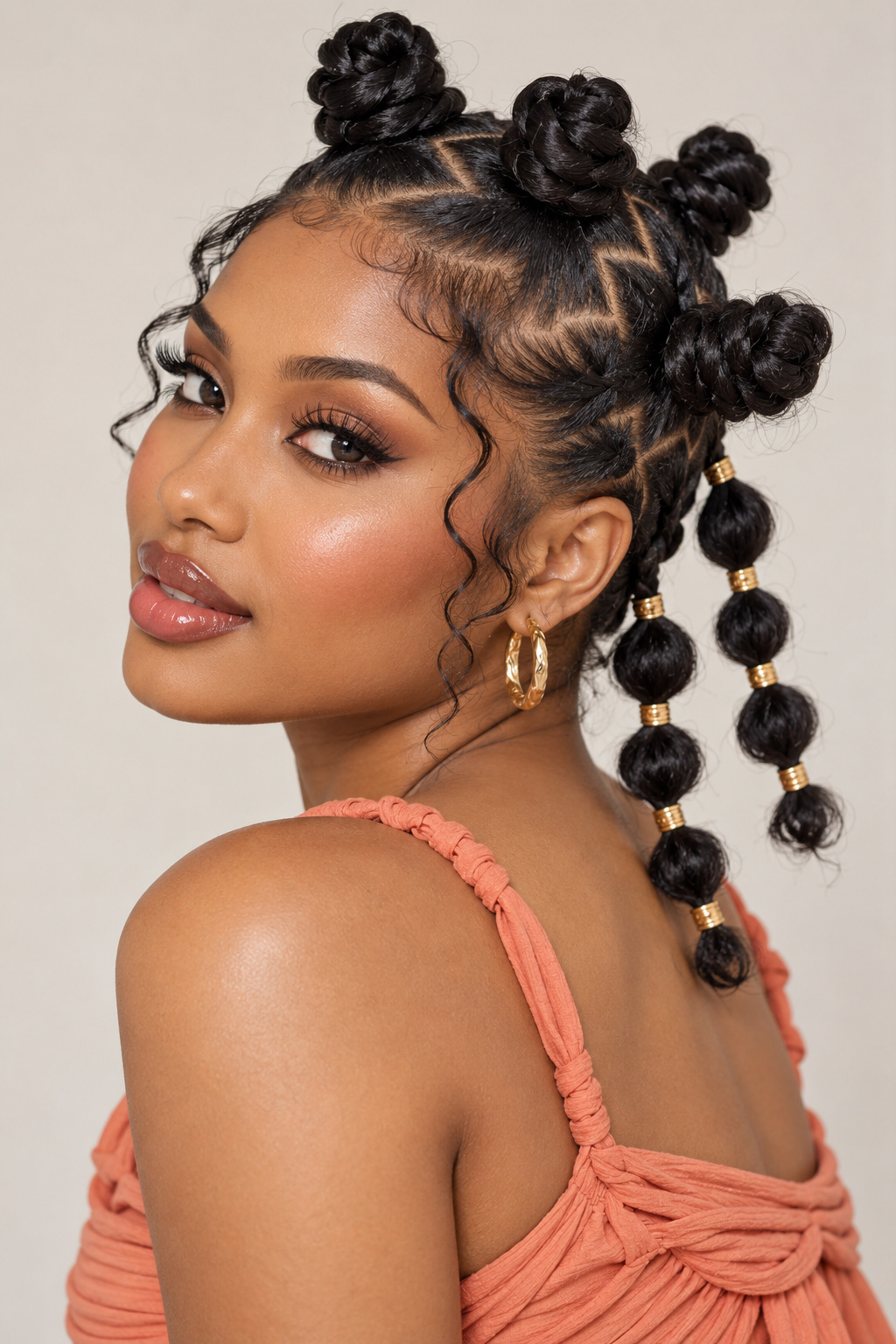Bantu knots styled with two long bubble-like segmented side braids in a three-quarter portrait.