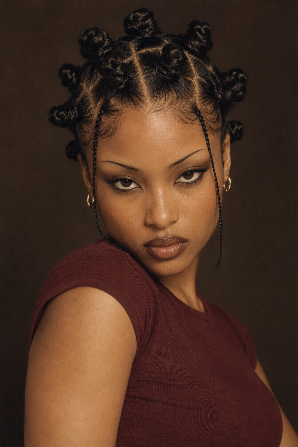 Small dark Bantu knots arranged in neat rows in a dramatic low-light portrait.